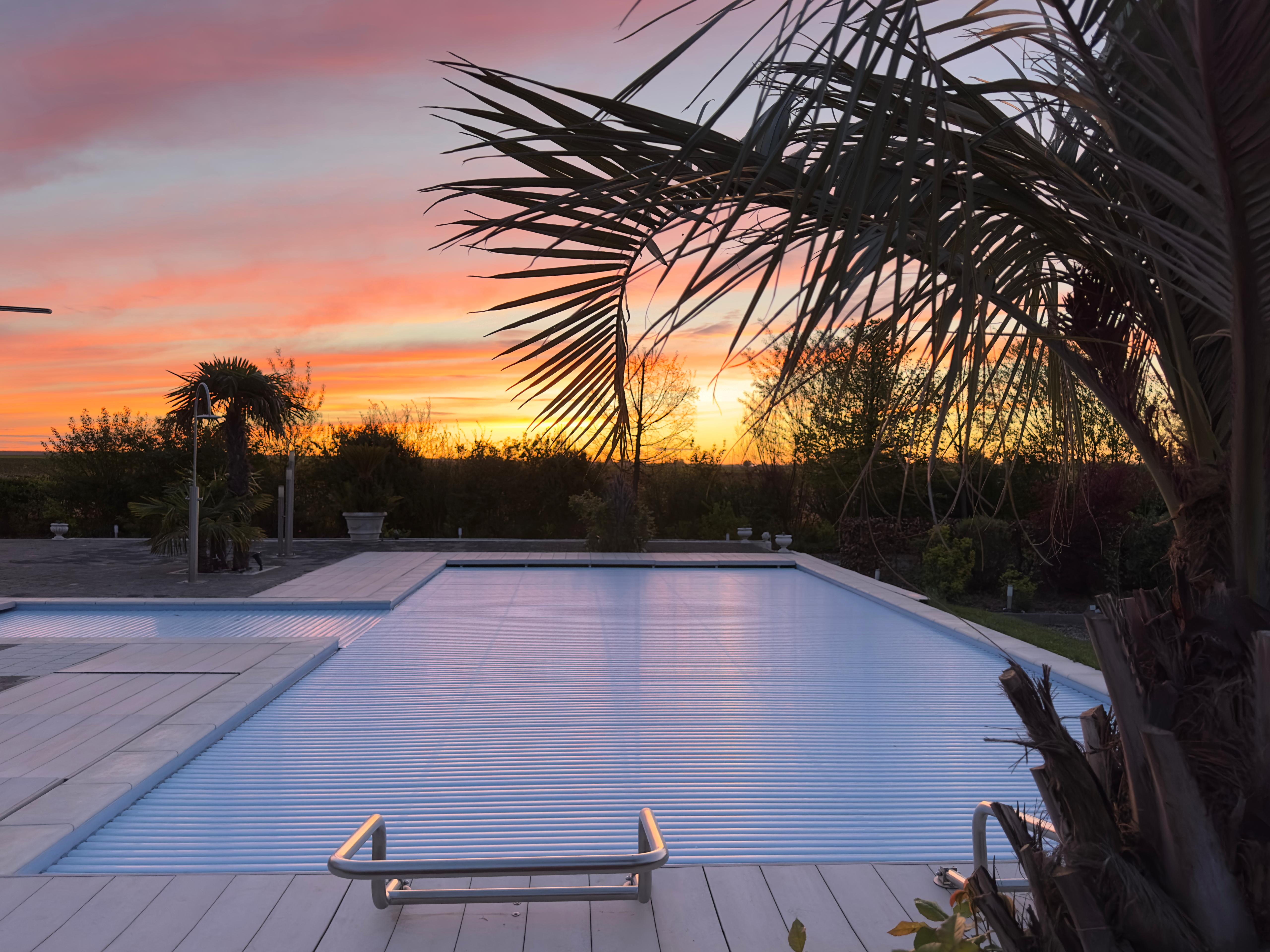 Sonnenuntergang am Pool des Anwesens mit warmer Lichtstimmung